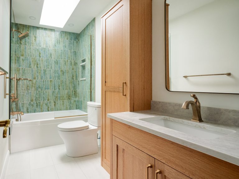 bathroom with toilet, cupboards, and tub